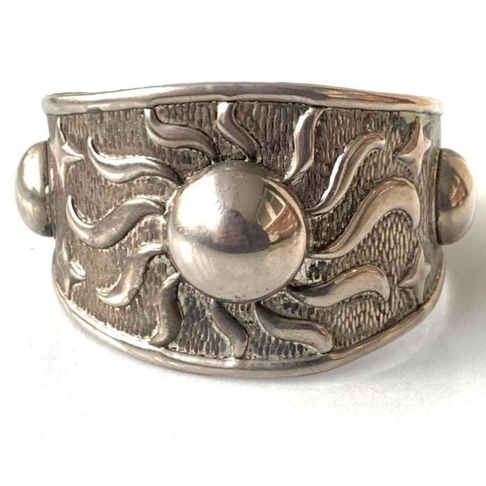 Silvertone cuff bracelet with sun and stars, swirls design